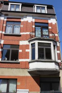 un grand bâtiment en briques avec un balcon. dans l'établissement Brussels BnB, à Bruxelles