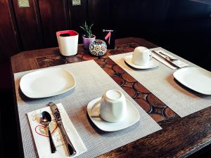 a wooden table with white plates and hats on it at Brunnenhof Randersacker - das kleine Hotel in Randersacker