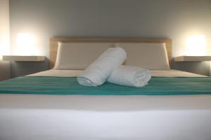 dois rolos de toalhas sentados em cima de uma cama em Il giardino di Artemide em Corato