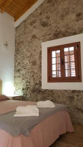 - une chambre avec un lit et un mur en pierre dans l'établissement Apartamento Casa Bibiana 1, à Hermigua