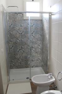 uma casa de banho com um chuveiro, um WC e um lavatório. em Il giardino di Artemide em Corato