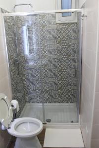 uma casa de banho com um chuveiro e um WC. em Il giardino di Artemide em Corato