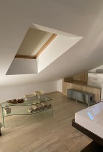 波爾托桑泰爾皮迪奧的住宿－Loft vista mare，一间带拱形天花板和玻璃桌的客厅