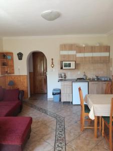 a living room with a table and a kitchen at Alsóhegyi Apartmanok in Zalakaros