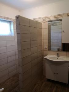 a bathroom with a sink and a mirror at Alsóhegyi Apartmanok in Zalakaros
