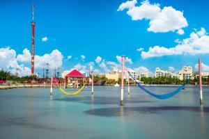 a beach with two swings in the water at Oasis Palm - All Inclusive in Cancún