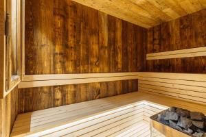 una sauna de madera vacía con un banco en ella en Podhalańskie Tarasy by LoftAffair, en Kościelisko