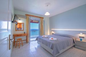 una camera con letto e tavolo e un balcone di Baywatch Apartments on the Beach ad Amoudi