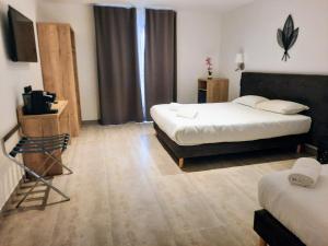 a hotel room with two beds and a television at Hôtel Casa Mea in Bastia