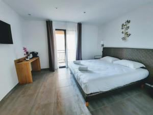 a bedroom with a large bed and a television at Hôtel Casa Mea in Bastia
