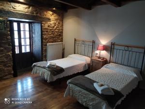 特里亞卡斯特拉的住宿－Albergue Atrio，一间卧室设有两张床和窗户。