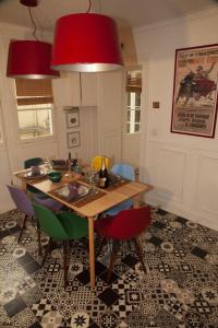 una sala da pranzo con tavolo in legno e sedie colorate. di Trendy and Chic in the heart of Saint-Germain des Prés a Parigi