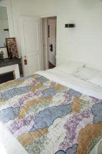 un letto con una trapunta colorata sopra di Trendy and Chic in the heart of Saint-Germain des Prés a Parigi