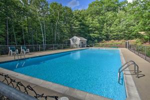 a swimming pool with two chairs and a house at Family-Friendly Condo with Mtn Views, Community Pool in Intervale