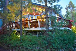 a large house with a large deck in the woods at Dream Getaway with Secluded Spa in Big Bear Lake