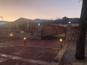 ein Gebäude mit Lichtern auf einem Parkplatz bei Sonnenuntergang in der Unterkunft Hostal La Posada de Mari in La Cabrera