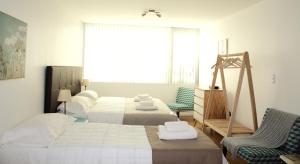 1 dormitorio con 2 camas, silla y ventana en Ona Shelter en Ushuaia