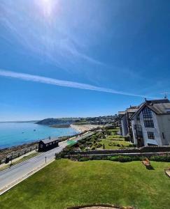 Blick auf den Strand, ein Gebäude und das Meer in der Unterkunft Membly Hall Hotel in Falmouth