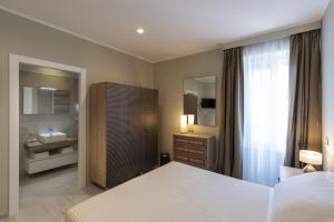 una camera da letto con un letto e un bagno con un lavandino di Gli Archi Spoleto a Spoleto