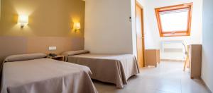 um quarto com duas camas e uma janela em Hotel Duna no Portonovo