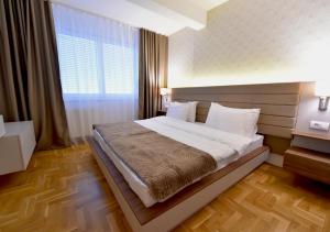 a bedroom with a bed and a large window at Sky lux apartman in Gornji Milanovac