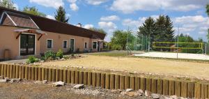 einen Zaun vor einem Haus mit einem Basketballplatz in der Unterkunft Penzion a hospůdka U Anny in Nové Sedlo