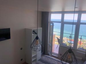 two hanging lights in a room with a view of the ocean at PANORAMA - Arcadia in Odesa