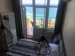 a bedroom with a large window with a view of the ocean at PANORAMA - Arcadia in Odesa