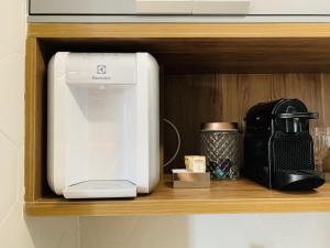 a coffeemaker and a coffee maker on a shelf at Downtown Luz Akilê in São Paulo