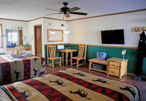 a bedroom with two beds and a table with a tv at Healing Waters Resort and Spa in Pagosa Springs