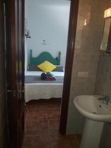 a small room with a small bed and a sink at El patio de Villa Pancho in Chipiona +9 photos