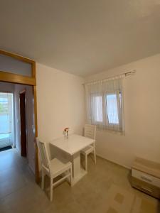 クルクにあるApartments Juraの窓付きの客室で、白いテーブルと椅子が備わります。