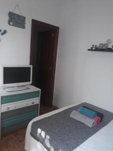 a bedroom with a bed and a tv on a dresser at El patio de Villa Pancho in Chipiona