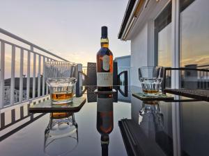 a bottle of wine and two glasses on a table on a balcony at Accommodation Mala Plaža in Podaca