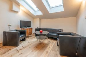 a living room with couches and a table and a tv at Nengshof Ferienhaus Glockenblume in Wißmannsdorf