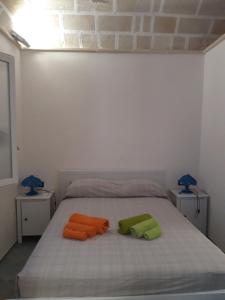 two towels sitting on a bed with two lamps at Il Cortiletto su levanzo in Favignana