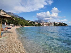 a group of people laying on a beach next to the water at Accommodation Mala Plaža in Podaca