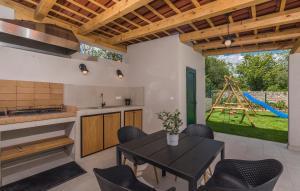 a kitchen with a table and chairs and a playground at Martinela Villas Istria - Villa Franko in Rojnići