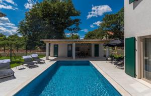 a swimming pool with chairs and a house at Martinela Villas Istria - Villa Franko in Rojnići +21 photos