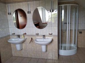 a bathroom with two sinks and mirrors on the wall at Ubytovanie pri Kúpeľoch in Bojnice