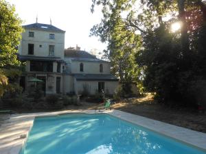 uma casa e uma piscina em frente a uma casa em Clos du Bois Brard B&B em Saumur
