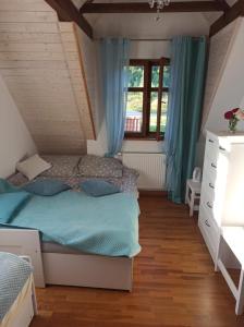 a bedroom with a bed and a window at Malowniczy Zakątek w Dercu in Derc