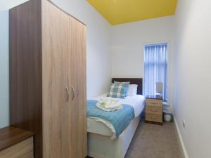 クルーにあるTownhouse @ Minshull New Road Creweのベッドルーム1室(ベッド1台付)、木製キャビネットが備わります。