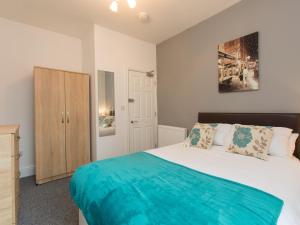 Schlafzimmer mit einem Bett und einem Holzschrank in der Unterkunft Townhouse @ Minshull New Road Crewe in Crewe