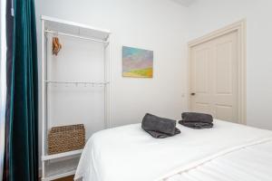 een slaapkamer met een wit bed met 2 kussens erop bij Charming Apartments in Alkmaar