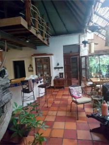una stanza con sedie e tavoli in una casa di Jungle Lodge CANCUN AEROPUERTO a Cancún