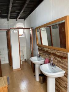 a bathroom with two sinks and a mirror and a toilet at Casa emblemática Buenavista del Norte in Buenavista del Norte