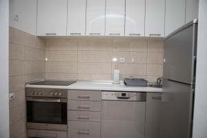 een keuken met witte kasten en een roestvrijstalen koelkast bij Oasis of Peace in Trebinje +11 foto's