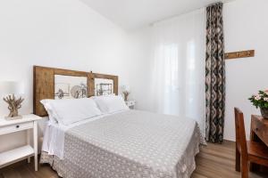 um quarto com uma cama branca e uma cabeceira em madeira em Ca' Mira - Room&Breakfast em Savio di Ravenna