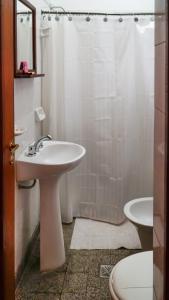 a white bathroom with a sink and a shower at Azul Humahuaca Hostal in Humahuaca